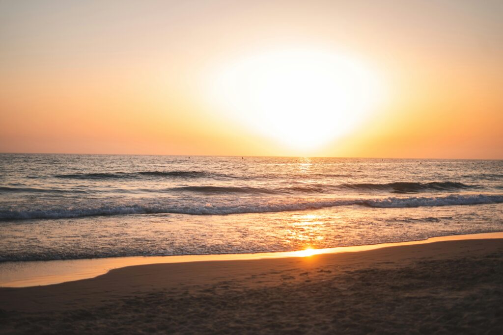Breathtaking sunset vista over Cádiz beach with gentle waves and golden sky reflection.